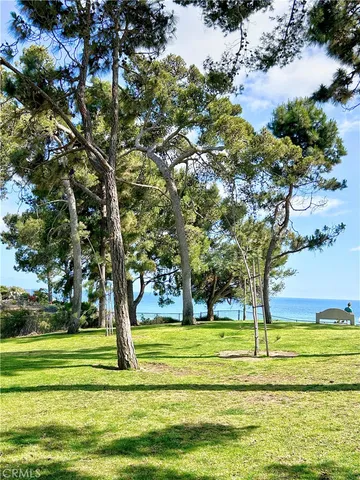 a view of a house with a big yard and palm trees
