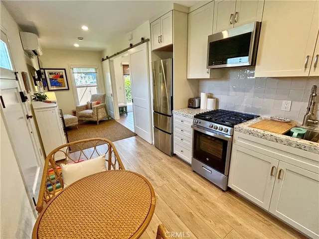 a kitchen with furniture a flat screen tv and a refrigerator