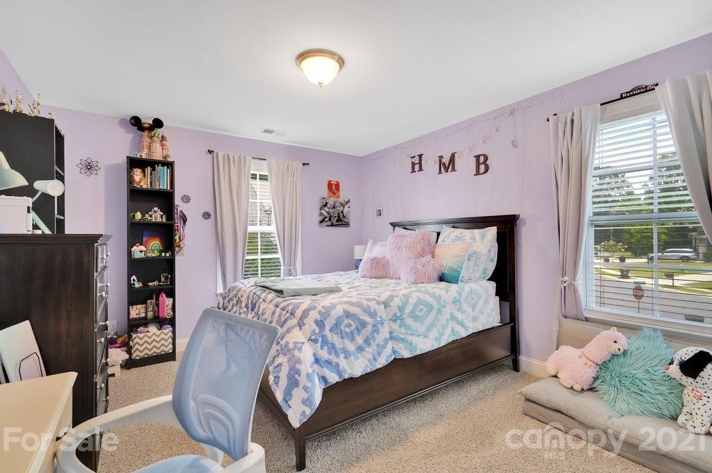 693 Old Cove Road Tega Cay, SC 29708 - Photo 17 of 38 a bedroom with a bed couch and a large window