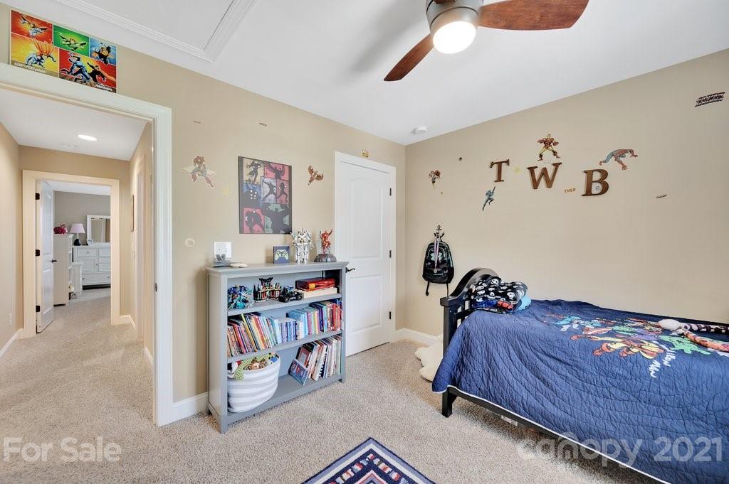 693 Old Cove Road Tega Cay, SC 29708 - Photo 22 of 38 a bedroom with a bed and a book shelf