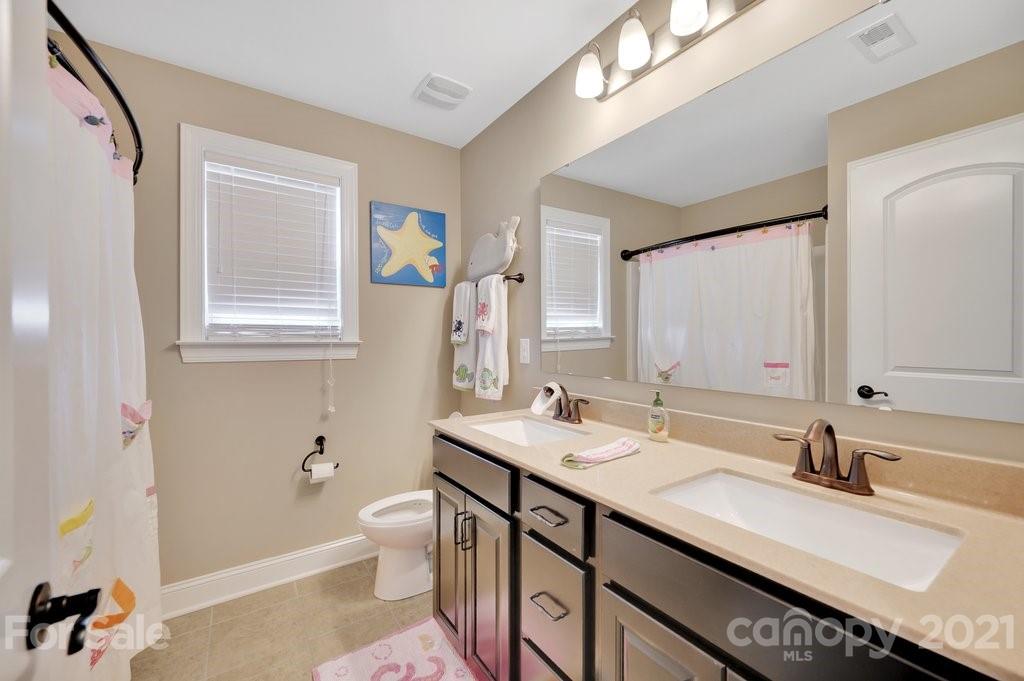 693 Old Cove Road Tega Cay, SC 29708 - Photo 23 of 38 a bathroom with a granite countertop sink mirror and a bathtub