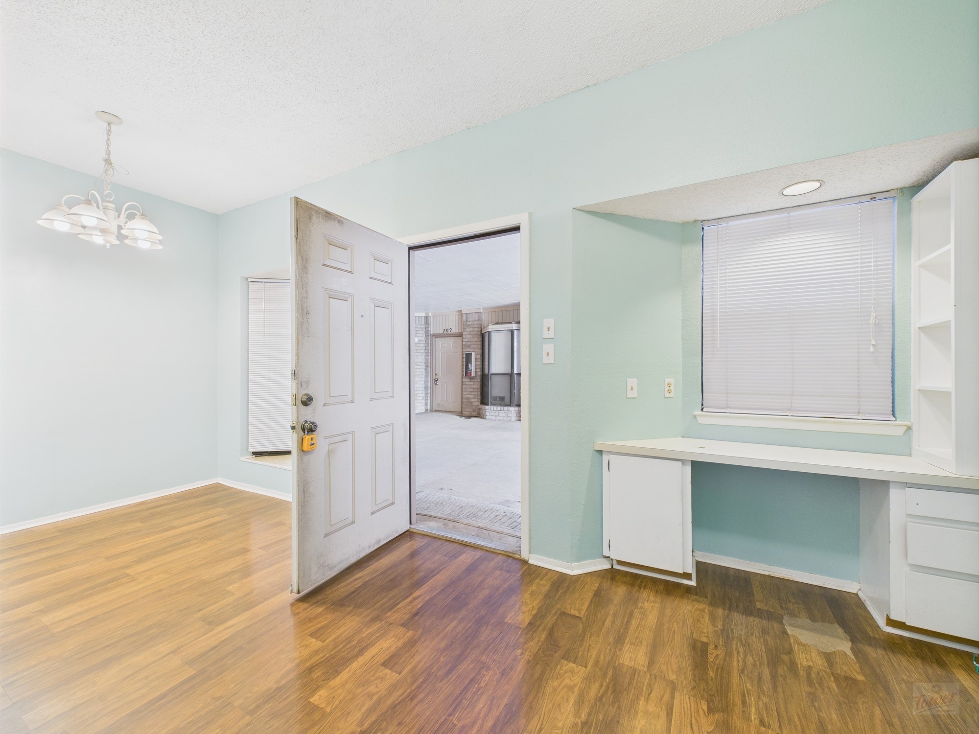 3316 Guadalupe Street, Unit 220 Austin, TX 78705 - Photo 3 of 14 a view of empty room with wooden floor and kitchen