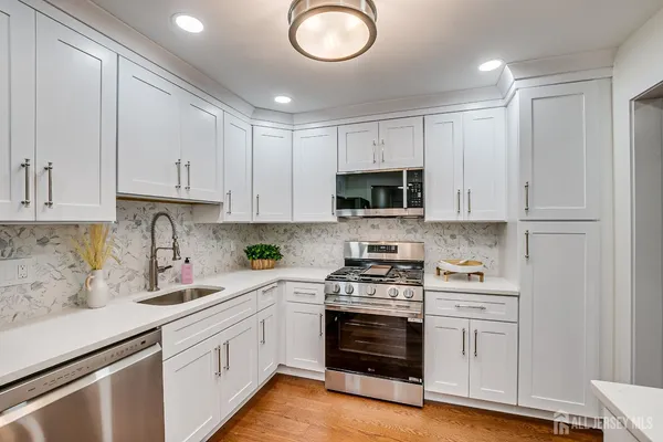 a kitchen with white cabinets and sink