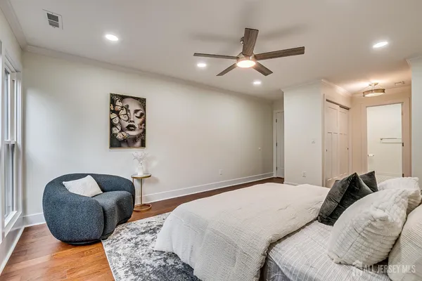 a bedroom with a bed a table and a potted plant