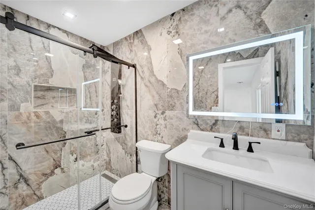 a bathroom with a sink vanity mirror and toilet