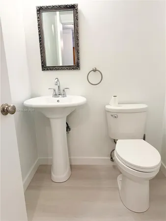a bathroom with a toilet sink and mirror