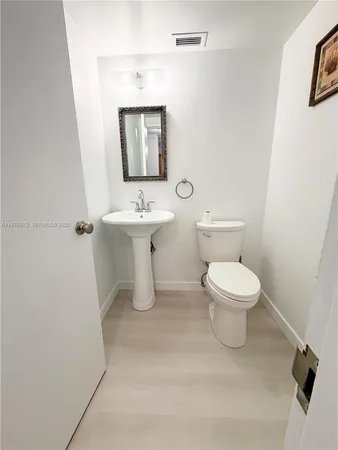 a white toilet sitting next to a bathroom sink