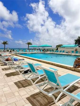a view of swimming pool with outdoor seating and city buildings