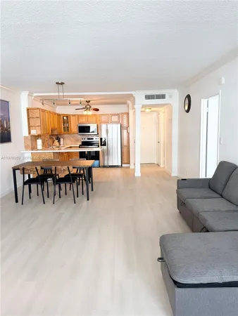 a living room with furniture and a dining table with kitchen view