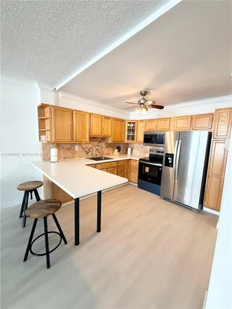 a living room with stainless steel appliances kitchen island granite countertop furniture and a view of kitchen