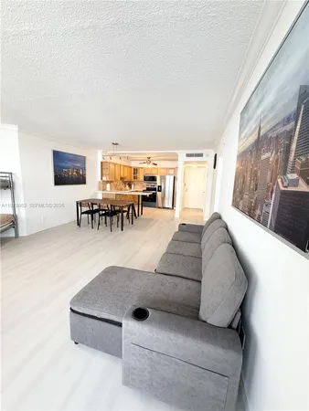 a living room with furniture and a dining table with kitchen view