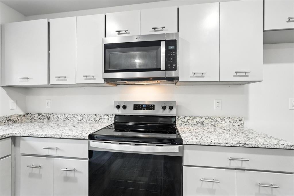 4613 Tarry Drive Garland, TX 75043 - Photo 12 of 38 a kitchen with granite countertop white cabinets and appliances