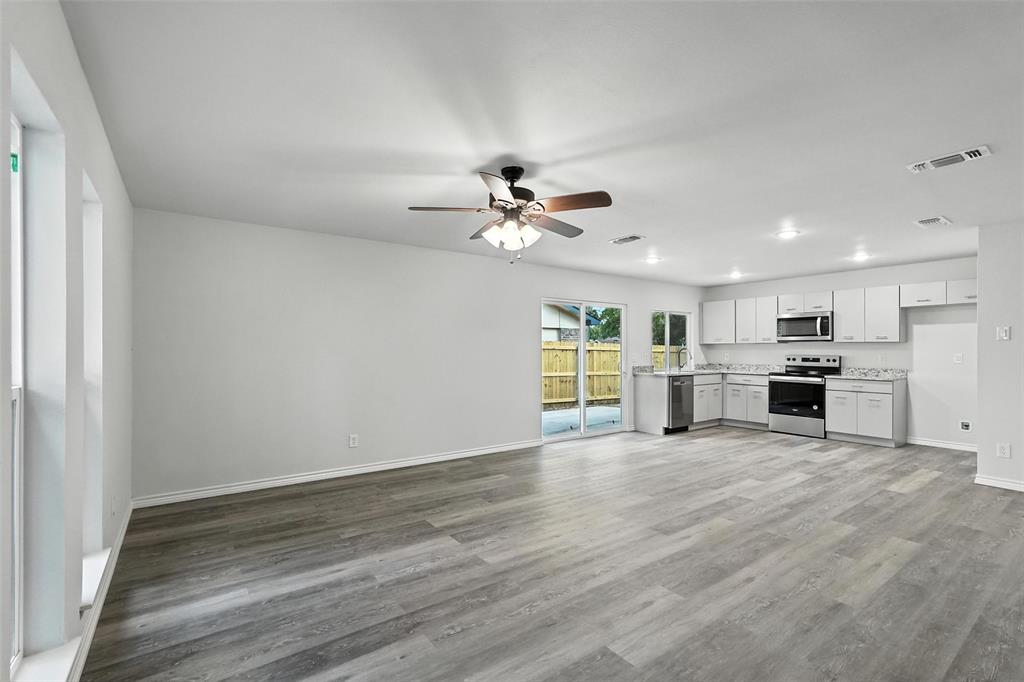 4613 Tarry Drive Garland, TX 75043 - Photo 14 of 38 a view of an empty room with a window and wooden floor