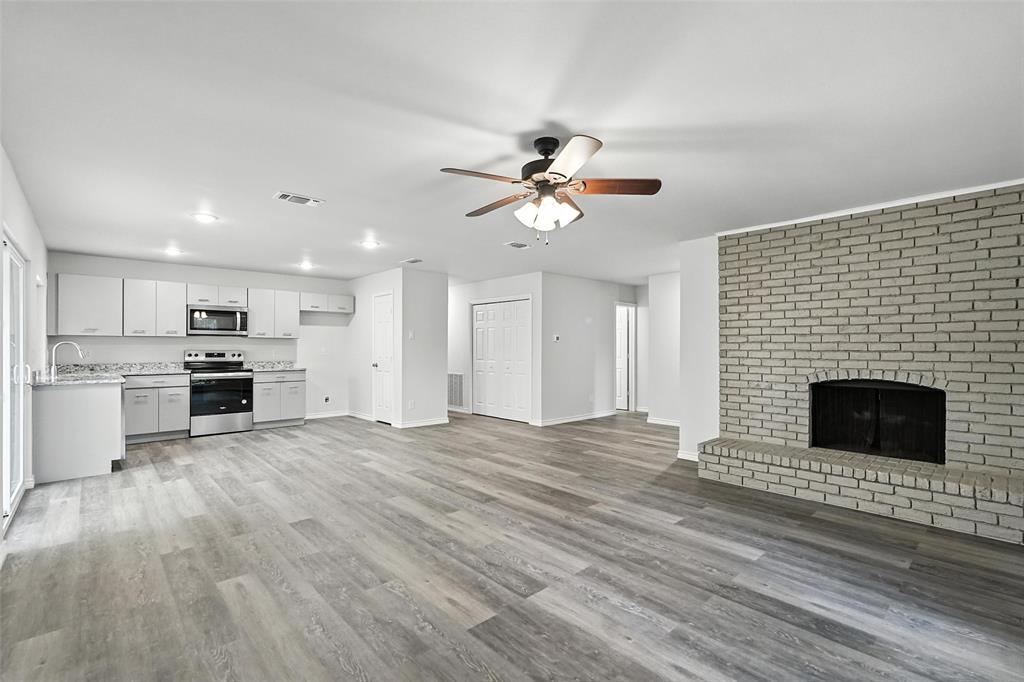 4613 Tarry Drive Garland, TX 75043 - Photo 5 of 38 a view of an empty room with kitchen and fireplace