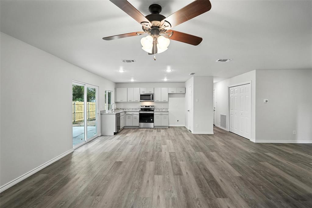 4613 Tarry Drive Garland, TX 75043 - Photo 6 of 38 a view of kitchen with microwave a stove and wooden floor