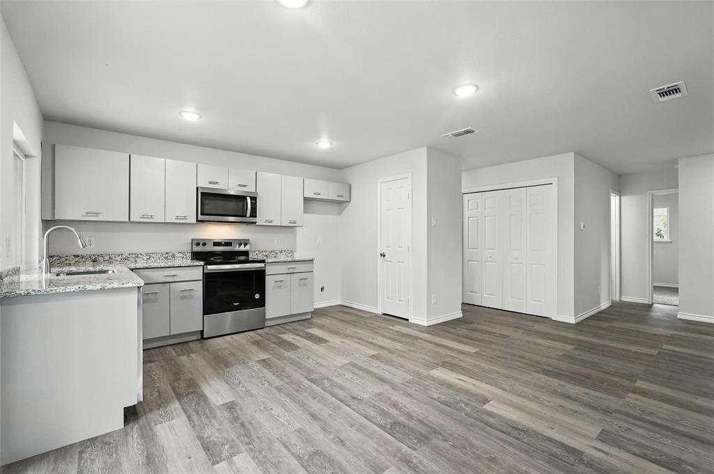4613 Tarry Drive Garland, TX 75043 - Photo 7 of 38 a kitchen with granite countertop a stove a sink and a refrigerator