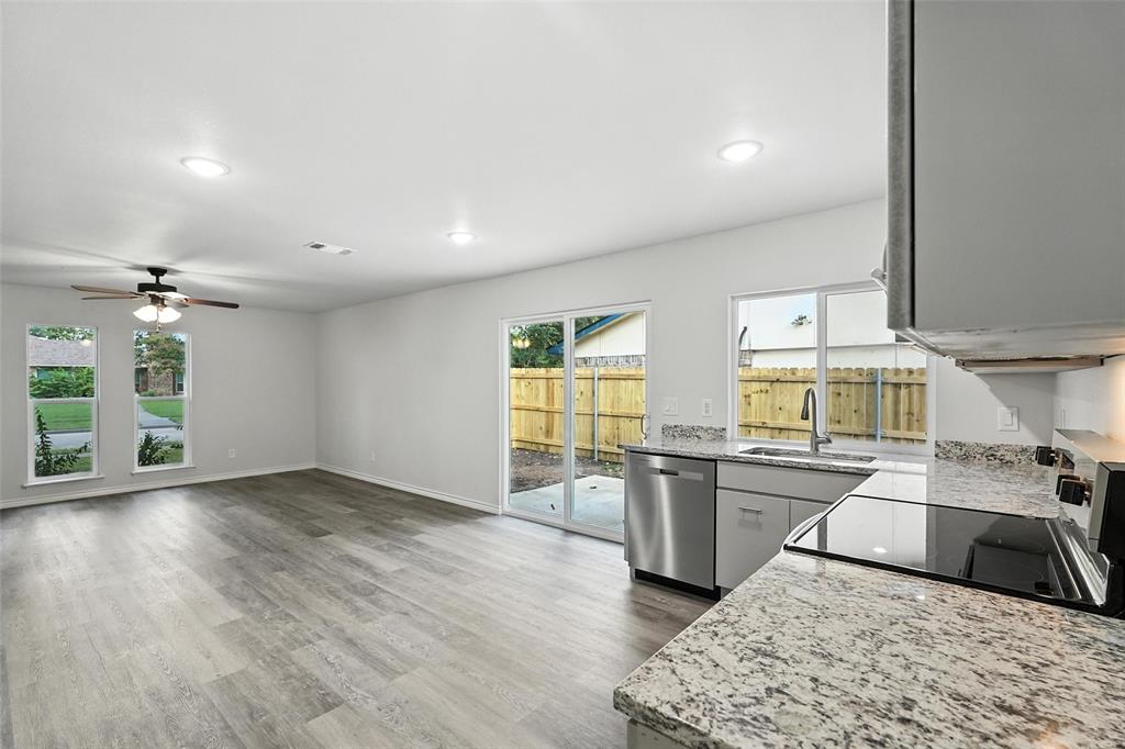 4613 Tarry Drive Garland, TX 75043 - Photo 9 of 38 a kitchen with stainless steel appliances granite countertop a stove and a wooden floors