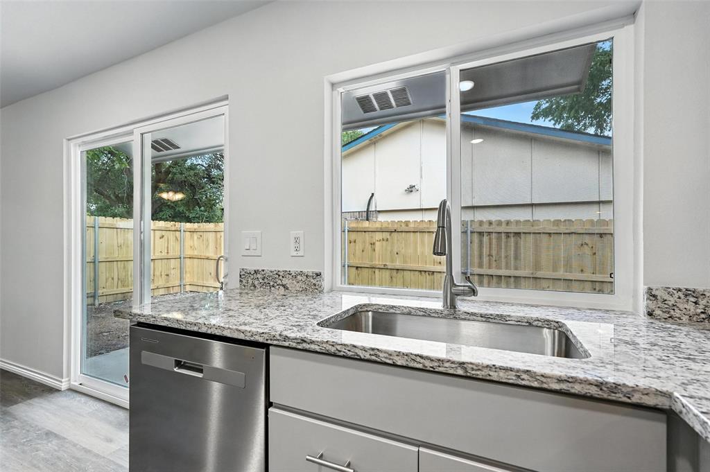 4613 Tarry Drive Garland, TX 75043 - Photo 10 of 38 a kitchen with granite countertop a sink and a large window