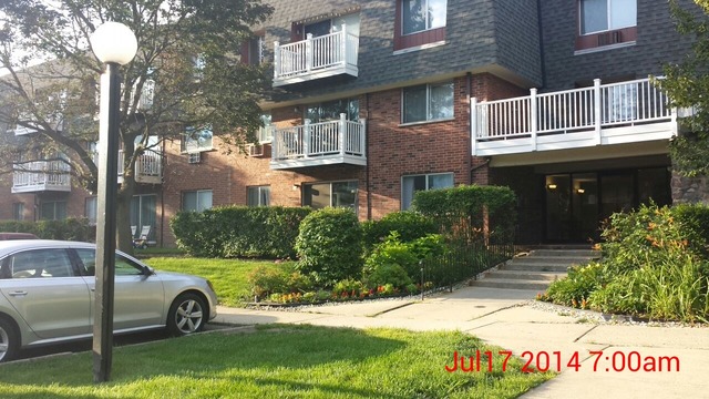 904 Ridge Square, Unit 105 Elk Grove Village, IL 60007 - Photo 1 of 12 a front view of a building with garden