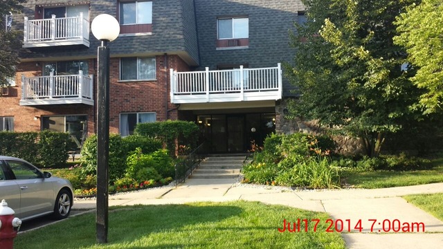 904 Ridge Square, Unit 105 Elk Grove Village, IL 60007 - Photo 2 of 12 a front view of a house with a yard