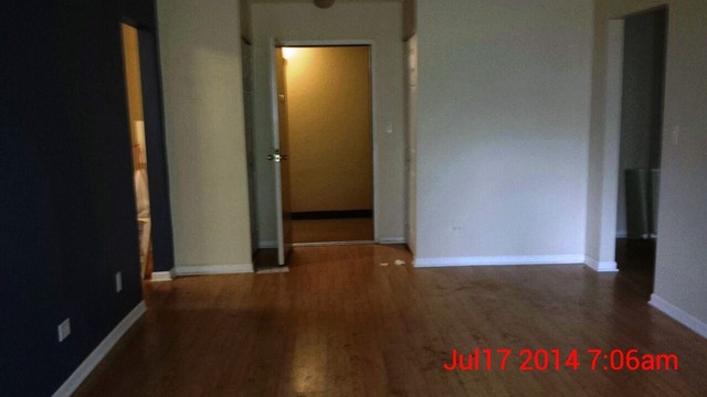 904 Ridge Square, Unit 105 Elk Grove Village, IL 60007 - Photo 5 of 12 an empty room with wooden floor and windows