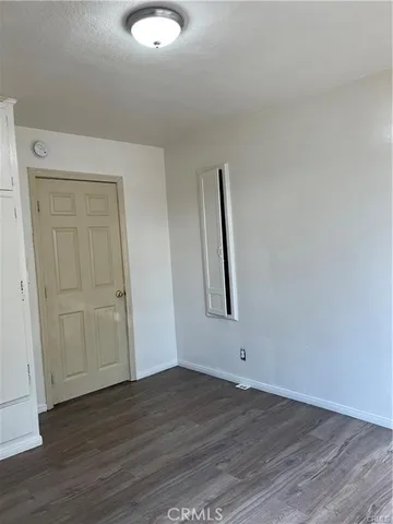 an empty room with wooden floor and window