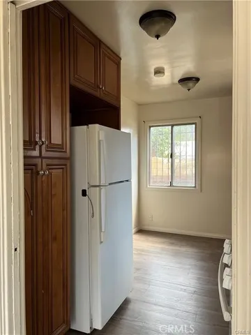 a view of kitchen with wooden floor and cabinets