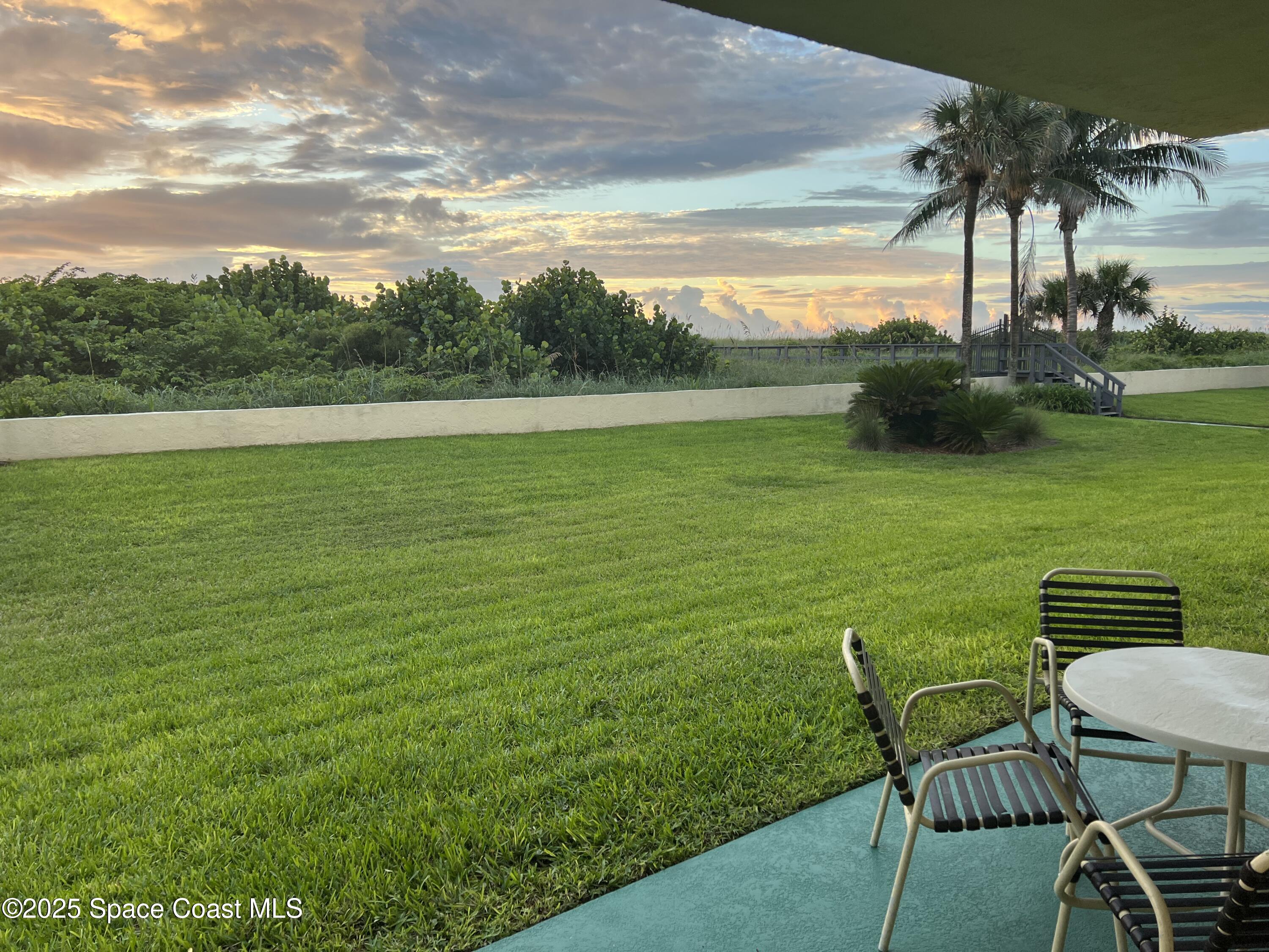 4570 Ocean Beach Boulevard, Unit 104 Cocoa Beach, FL 32931 - Photo 14 of 18 a view of a table and chairs in the garden