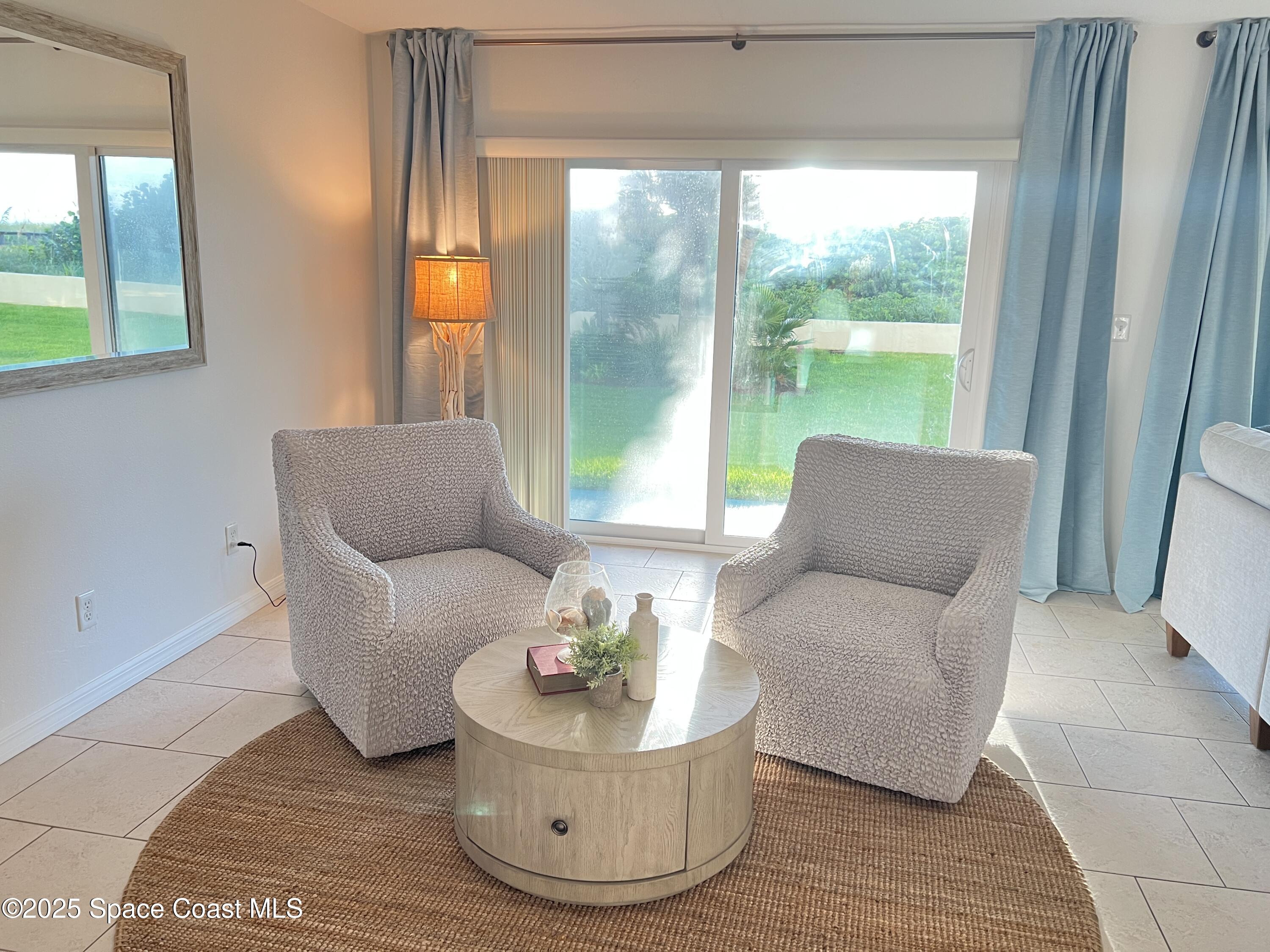 4570 Ocean Beach Boulevard, Unit 104 Cocoa Beach, FL 32931 - Photo 5 of 18 a living room with furniture and a window