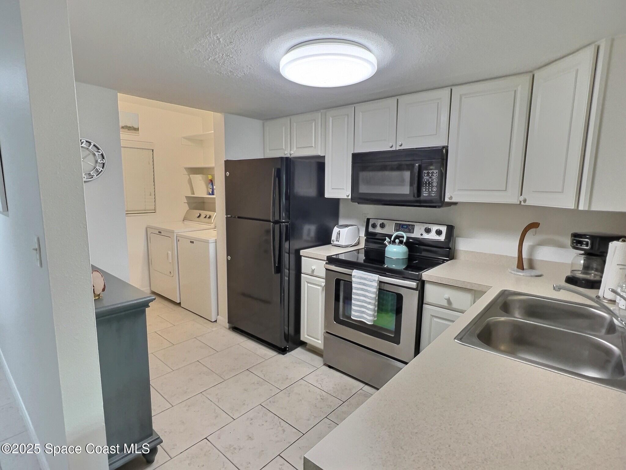 4570 Ocean Beach Boulevard, Unit 104 Cocoa Beach, FL 32931 - Photo 10 of 18 a kitchen with a refrigerator stove and sink