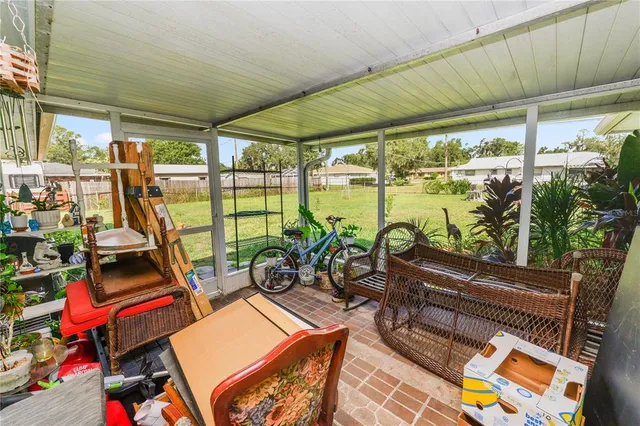 a living room with patio furniture and a floor to ceiling window