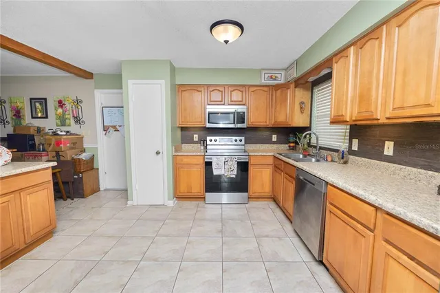 a large kitchen with stainless steel appliances granite countertop a stove a sink dishwasher and a refrigerator