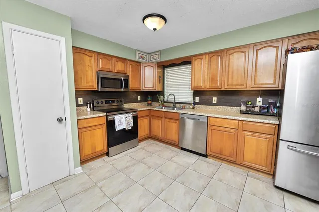 a kitchen with stainless steel appliances granite countertop a stove sink microwave and refrigerator