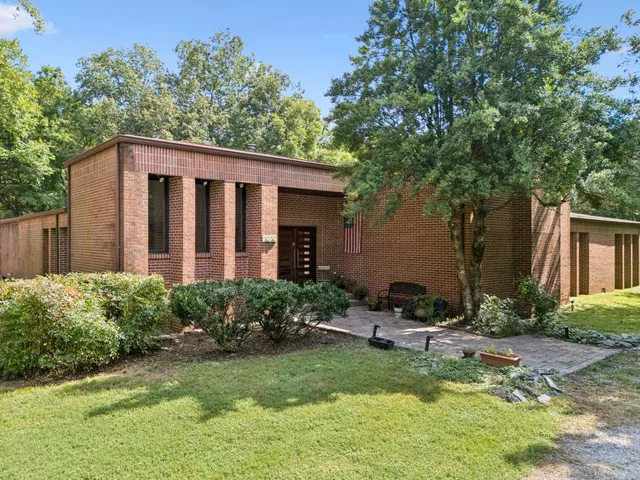 a view of a house with backyard and sitting area