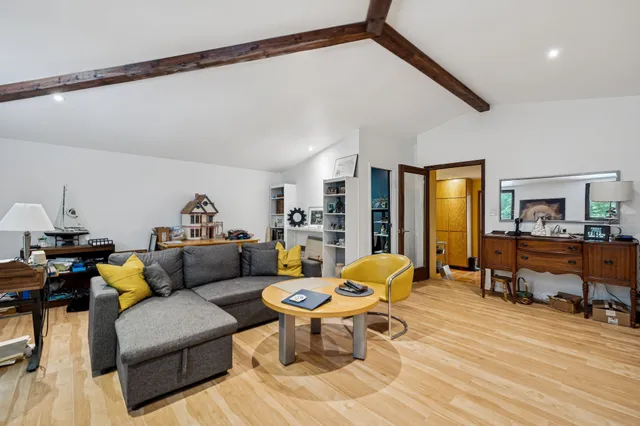 a spacious bedroom with a bed and wooden floor