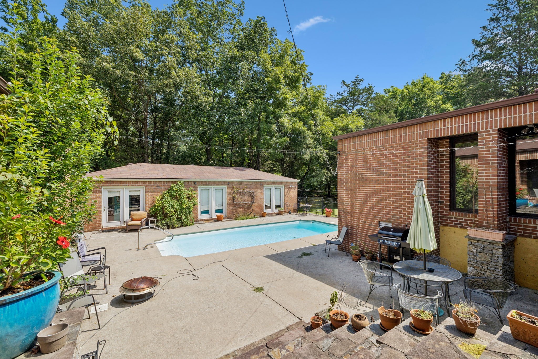 1030 Waller Road Brentwood, TN 37027 - Photo 7 of 90 a view of a patio with table and chairs potted plants and large tree