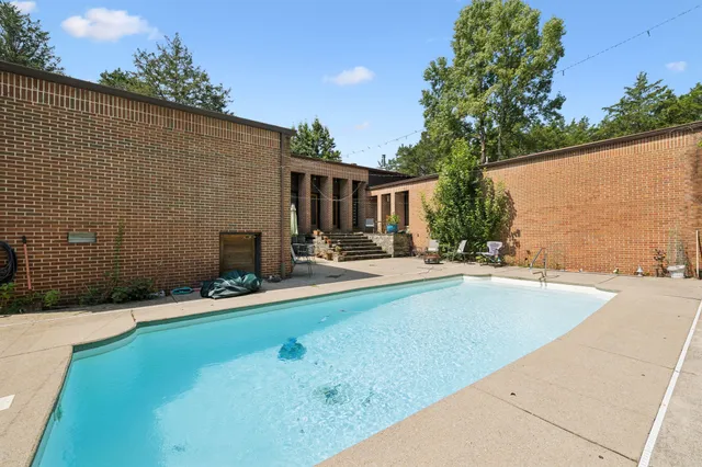 a view of a house with swimming pool and sitting area