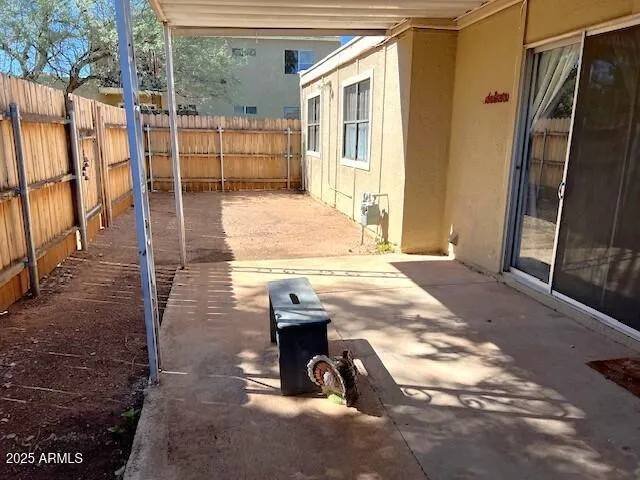 a view of a backyard with wooden fence and large windows