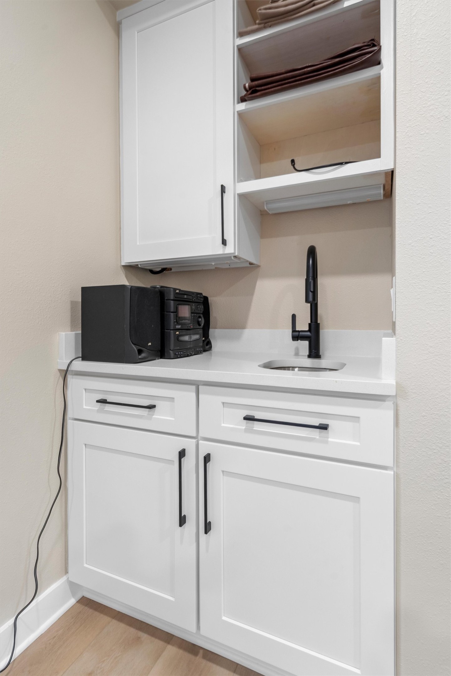 307 Hurst Creek Road Austin, TX 78734 - Photo 24 of 40 White shaker cabinetry with matte black hardware, integrated sink, and wall-mounted faucet