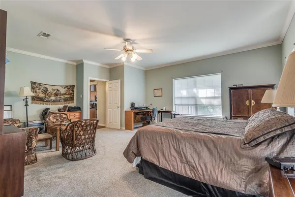 a bedroom with bed a chandelier and a window
