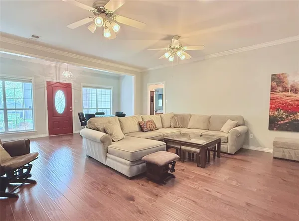 a living room with furniture or chandelier and a wooden floor