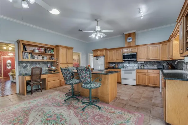 a kitchen with cabinets and chairs