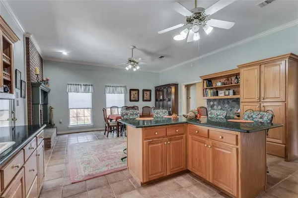 a kitchen with kitchen island granite countertop a sink and cabinets