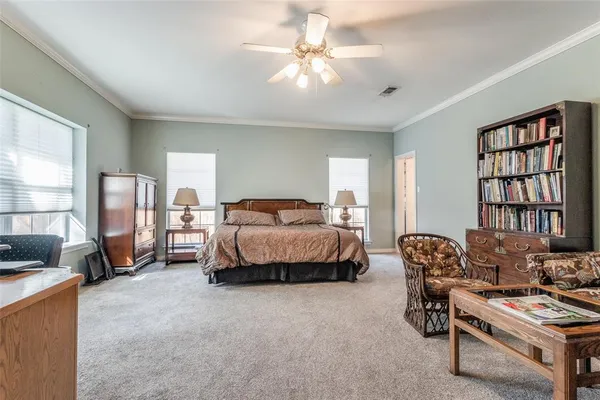 a spacious bedroom with a bed and a chandelier