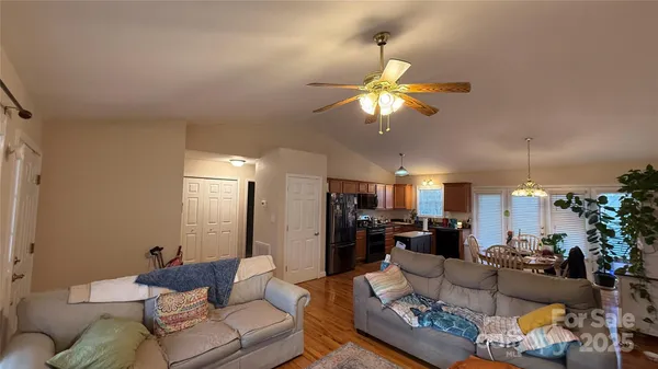 a living room with furniture kitchen view and a chandelier