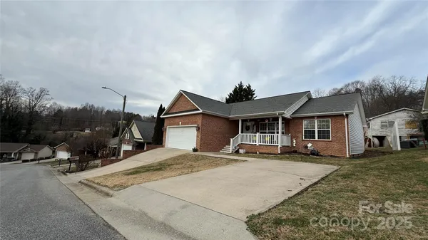 a front view of a house with a yard and trees