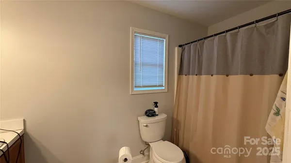 a bathroom with a toilet and a shower curtain