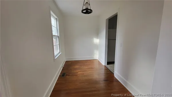 a view of a hallway with wooden floor and a window