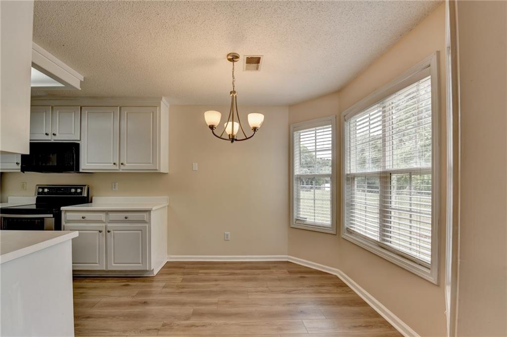 601 Bowling Lane Winder, GA 30680 - Photo 16 of 45 a view of an empty room with a kitchen and a window
