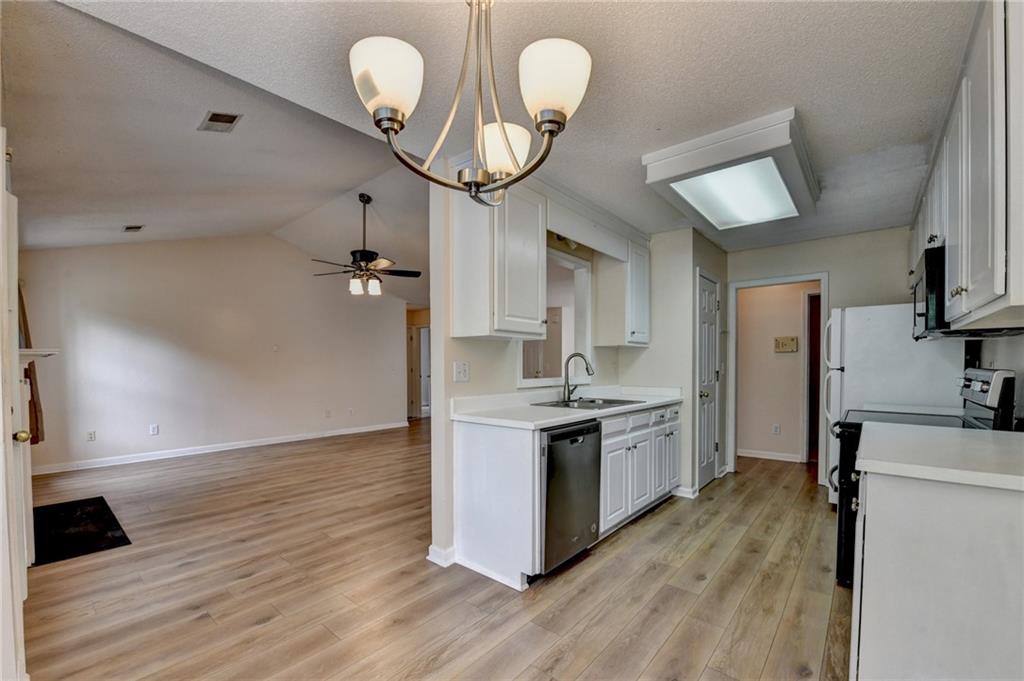 601 Bowling Lane Winder, GA 30680 - Photo 18 of 45 a kitchen with granite countertop a stove a sink and a refrigerator
